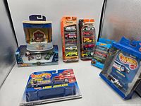 Photo showing assortment of Hot Wheels and Matchbox collectible toy vehicles including holiday sets, 5-packs, 3-pack, Rigor Motor, and Long Haulers truck.