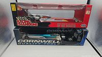 Side view showing two 1:24 scale die-cast dragsters in original packaging stacked, Racing Champions on top and Cornwell below.