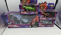 Four WWF Attitude Racing diecast dragsters in original packaging, three 1:43 scale and one 1:24 scale, grouped together