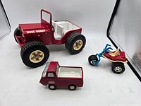 Photo of all three toys together showing the red Tonka dune buggy, the small red Tonka truck, and the blue and red trike.