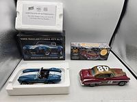Diecast models displayed with original boxes and certificate of authenticity for Shelby Cobra