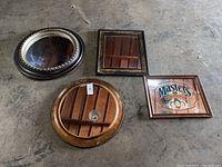 Four various sized mirrors laid on floor showing frames and reflective surfaces with scratches and dirt.