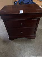 Front view of the brown wood night stand showing two drawers and overall structure.