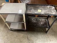 Photo shows two rolling carts positioned side by side, left one is grey plastic with three shelves, right one is black metal with two shelves and is visibly worn