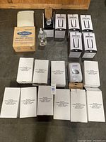 Array of boxed soap dispensers including Bobrick and Hillyard dispensers, a liquid soap bottle, and five Tork AutoFoam dispensers in boxes.