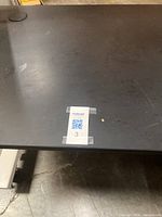 Image of black rectangular workstation table top surface with MaxSold label