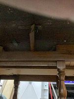 Underside of the antique wooden table showing structural braces and support beams.