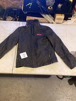 Front view of the black Bench jacket laid flat showing the full jacket with visible zippers and red Bench logo on chest.