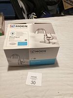 Boxed Moen Boutique B4020 kitchen faucet showing product name and branding on box.