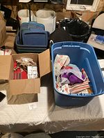 View of bins and boxes containing sewing and knitting supplies on table