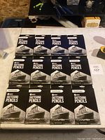 Twelve boxed sets of Pencil Buddies sketching pencils arranged on a tabletop.