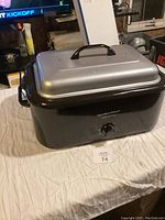 Hamilton Beach roaster oven closed with lid on a white cloth surface