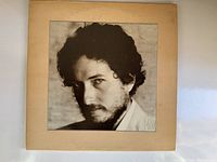 Front cover of the Bob Dylan vinyl album showing black and white portrait on a beige background.