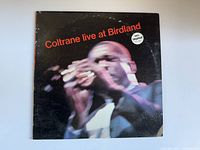 Front cover of John Coltrane 'Coltrane live at Birdland' vinyl album showing image of saxophone player and MCA Impulse! sticker.