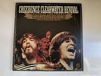 Front cover of the Creedence Clearwater Revival album 'Chronicle The 20 Greatest Hits' showing band members' photos and album title.