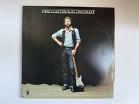 Front cover of the Eric Clapton album showing artist holding guitar.