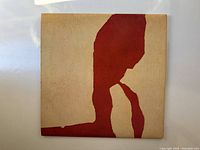 Front cover of the vinyl album sleeve with minimalist red and cream abstract design.