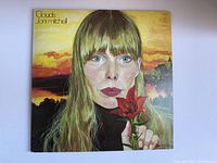 Front cover of the vintage Joni Mitchell "Clouds" vinyl album featuring painted portrait and sunset background.