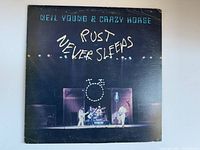 Front of the album cover showing Neil Young & Crazy Horse performing with the title 'Rust Never Sleeps'.