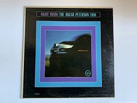 Front cover of the vinyl record album showing 'Night Train: The Oscar Peterson Trio' with a blurred train image and color borders.