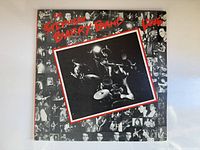 Front cover of the Stephen Barry Band 'Live' vinyl record album, showing band performing and surrounding photos.
