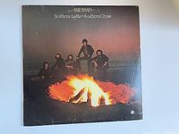 Front cover of The Band vinyl album featuring members around campfire with wear and tear visible.