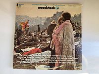 Front cover of vintage Woodstock vinyl record album showing crowd scene and list of featured artists.