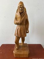 Front view of the wooden carved habitant man figure showing traditional clothing and facial features.