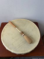 Top-down view of drum head with striker laid across