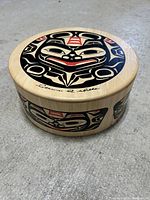 Top and side view of the circular wooden box showing Haida design and signature.