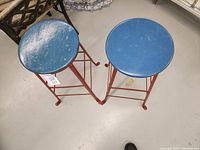 Top view showing two round blue seats and red legs of the stools.