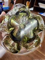 Bottom view of the green glass bowl showing the flower-shaped detail inside the base.