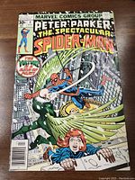 Full front cover of the comic showing Spider-Man swinging with villain and woman on rooftop, title and other cover elements visible.