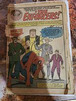 Photo of inside comic page featuring Spiderman with the Enforcers introduction, showing aging and wear, no cover visible.