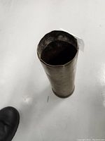 Top view of the open brass shell casing showing interior and dented rim.