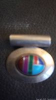 Photo of the front side of the sterling silver Navajo pendant highlighting the multi-stone colorful inlay design.