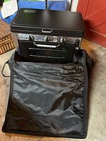 Front view of stove resting in open black nylon carrying case