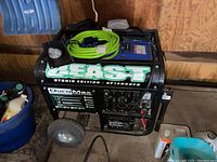 Side view of generator showing frame, wheels, cover, cable