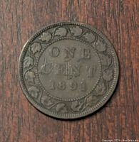 Photo of the reverse side of the 1891 Canadian one cent coin showing denomination and year with maple leaf border.
