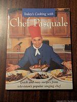 Front cover of 'Today's Cooking with Chef Pasquale' hardcover cookbook showing Chef Pasquale with plates of food, title and subtitle.