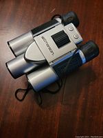 Full view of silver and black Emerson binoculars showing focus wheel and eyecups