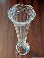 Top view showing scalloped wavy rim with bead and leaf motifs and clear fluted crystal body.