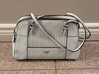 Front view showing perforated panel with Guess logo and adjustable shoulder strap