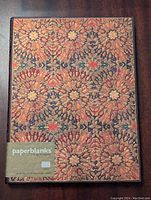 Front cover of Paperblanks Fire Flowers Ultra journal showing intricate floral pattern with embossed texture and product label.