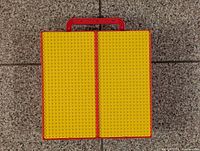 Top view of case showing yellow LEGO stud-compatible plates designed for building and holding LEGO bricks.
