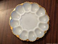 Top view of the milkglass dish showing white opaque surface with scalloped gold trim edge.