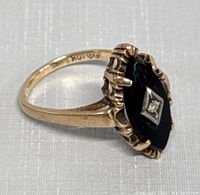 Side angle of ring showing marquise onyx cabochon and prong-set diamond