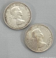 Obverse side of two 1958 Canadian silver dollar coins showing Queen Elizabeth II profile and inscriptions.