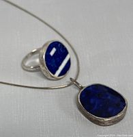 Close-up photo of the ring and pendant showing the deep blue lapis stones set in 925 silver.