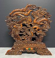 Front view of the carved boxwood screen showing dragon and phoenix motif and embedded green stones on base.